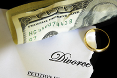 torn divorce decree and cash, with wedding ring