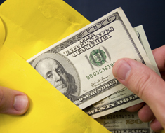 Hands unpacking a yellow envelope with money