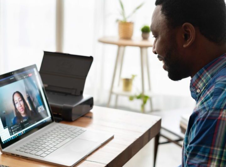 man viewing virtual meeting on laptop