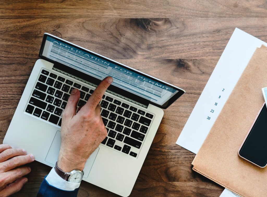 person pointing at laptop screen