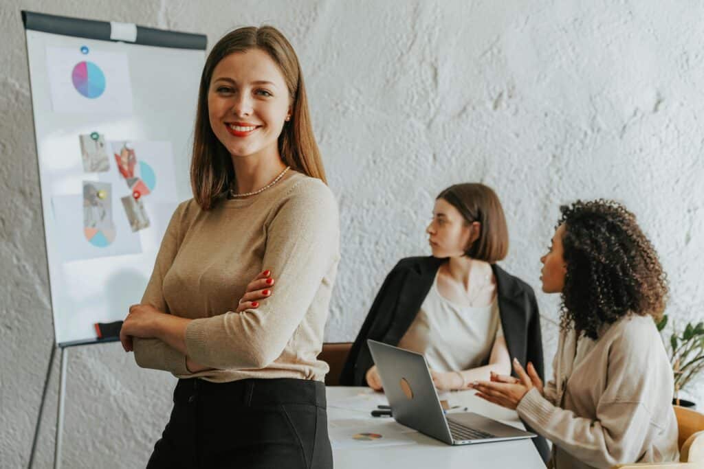 woman stands in meeting with presentation materials