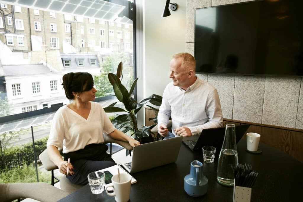 man and woman meet in office next to computer